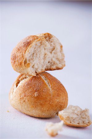 Half a bread roll on top of a whole one Stock Photo - Premium Royalty-Free, Code: 659-06187047