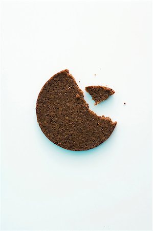 simsearch:659-08512915,k - A slice of pumpernickel bread with a bite taken out Stock Photo - Premium Royalty-Free, Code: 659-06187068