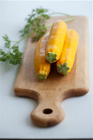 simsearch:659-06155811,k - Three yellow courgettes on a chopping board Fotografie stock - Premium Royalty-Free, Codice: 659-06187176