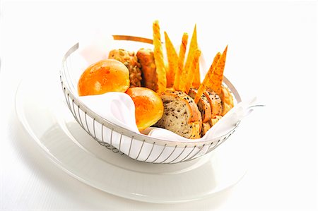 Bread rolls, sliced bread and bread sticks in a bread basket Stock Photo - Premium Royalty-Free, Code: 659-06187333