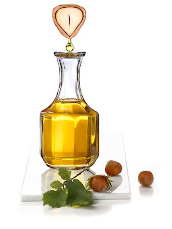 Hazel nut oil dropping from a hazel nut into a carafe Stock Photo - Premium Royalty-Free, Code: 659-06187632