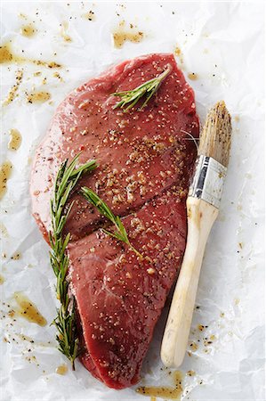 simsearch:659-08147438,k - Raw Steak in a Rosemary Marinade on Butcher's Paper; Basting Brush Foto de stock - Sin royalties Premium, Código: 659-06187787