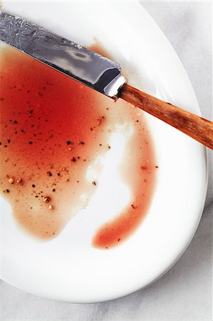 remainder - Juices from a Cooked Steak on a White Plate; Knife Stock Photo - Premium Royalty-Free, Code: 659-06187793