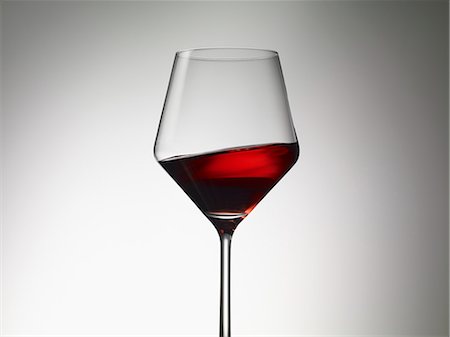 red wine glass spilled - Red wine sloshing in a wine glass Stock Photo - Premium Royalty-Free, Code: 659-06187869