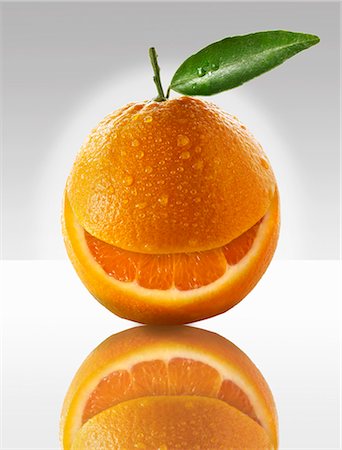One orange with a slice taken out of it Stock Photo - Premium Royalty-Free, Code: 659-06187911
