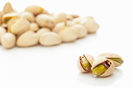 Toasted pistachios against a white background Foto de stock - Sin royalties Premium, Código: 659-06187987