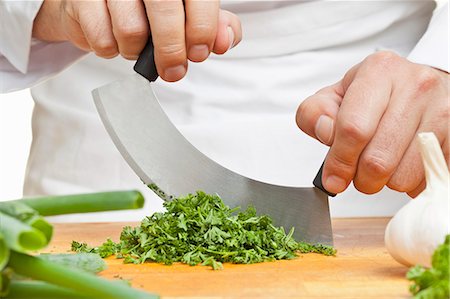 simsearch:659-06187981,k - Chopping curly parsley with a mezzaluna knife Foto de stock - Sin royalties Premium, Código: 659-06187980