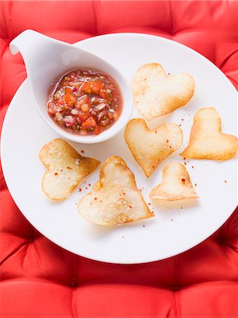 potatochips - Heart-shaped crisps with a salsa dip Stock Photo - Premium Royalty-Free, Code: 659-06188247