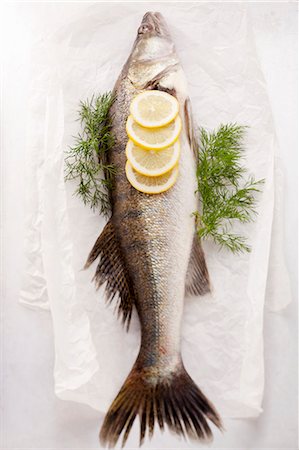 pescado - Fish with lemons and dill on parchment paper Foto de stock - Sin royalties Premium, Código: 659-06188272