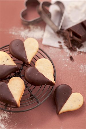 sweet heart shape - Heart-shaped biscuits with chocolate icing on a wire rack Stock Photo - Premium Royalty-Free, Code: 659-06188289