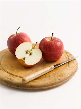 simsearch:659-06187916,k - Red apples, whole and halved, on a wooden table Stock Photo - Premium Royalty-Free, Code: 659-06188487