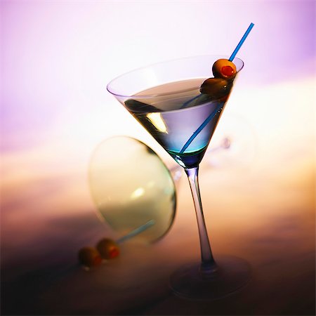 Vodka Martini with Olives; Tipped Martini Glass in Background Stock Photo - Premium Royalty-Free, Code: 659-06183820