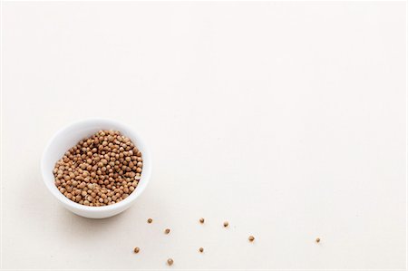 Coriander seeds in a bowl and next to it Stock Photo - Premium Royalty-Free, Code: 659-06183873