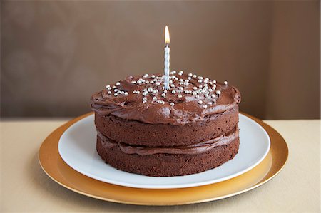 A chocolate cake decorated with silver balls and a candle Foto de stock - Sin royalties Premium, Código: 659-06183925