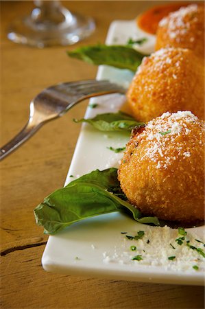 Deep Fried Risotto Balls on a Platter with Parmesan Cheese Foto de stock - Sin royalties Premium, Código: 659-06306203