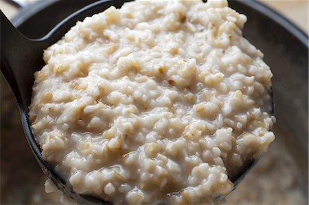 farinha de aveia - A Ladle of Oatmeal Straight From the Pot Foto de stock - Royalty Free Premium, Número: 659-06306423