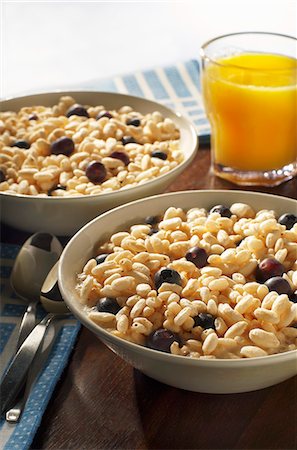 Two Bowls of Puffed Rice Cereal with Fresh Blueberries and Orange Juice Foto de stock - Sin royalties Premium, Código: 659-06306482