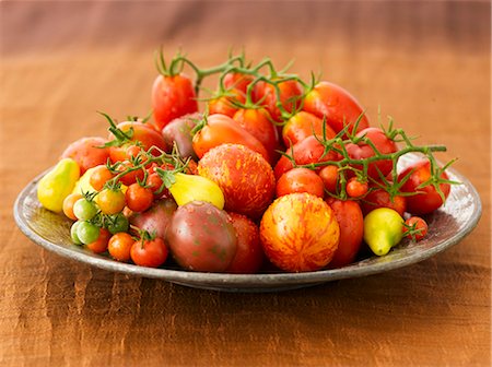 A Variety of Freshly Washed Heirloom Tomatoes on a Large Plate Foto de stock - Sin royalties Premium, Código: 659-06306494