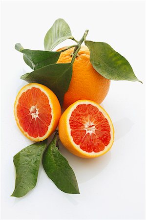 fruit on white background - Blood oranges, whole and halved, with leaves Stock Photo - Premium Royalty-Free, Code: 659-06306516