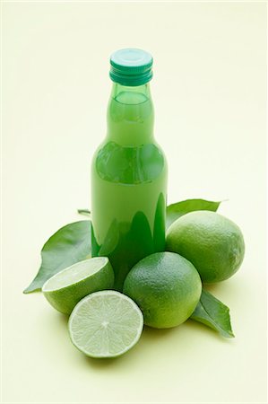 simsearch:659-06306561,k - Une bouteille de jus de lime et limes fraîches Photographie de stock - Premium Libres de Droits, Code: 659-06306525