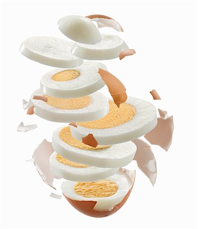 Sliced hard-boiled egg and egg shell flying through the air Foto de stock - Sin royalties Premium, Código: 659-06306555