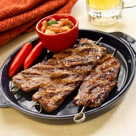 simsearch:659-01862796,k - Grilled Beef Skewers on a Platter with Pinto Bean Relish; Red Chili Peppers Foto de stock - Sin royalties Premium, Código: 659-06306594