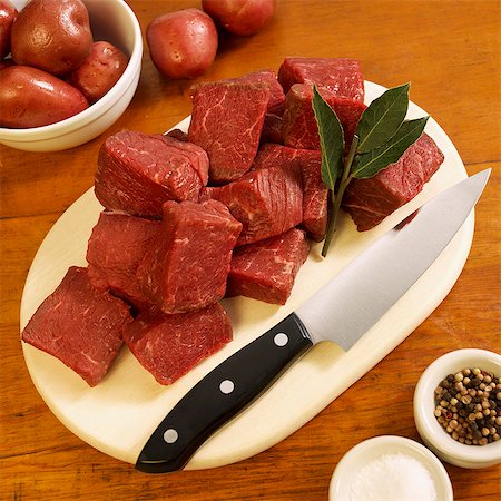 Cubed Grass Fed Beef Sirloin Tips on Cutting Board; Peppercorns, Salt and Red Potatoes Foto de stock - Sin royalties Premium, Código: 659-06306591