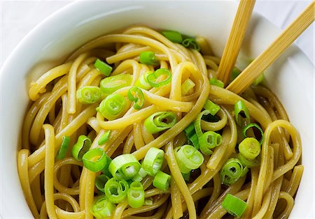 Bol de nouilles sésame avec des oignons verts tranchés et baguettes Photographie de stock - Premium Libres de Droits, Code: 659-06306680