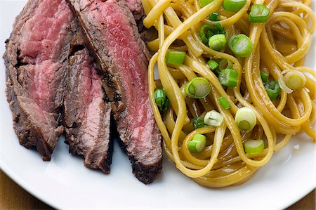 simsearch:659-07068578,k - Sliced Steak with Sesame Noodles with Scallions; On a Plate From Above Stock Photo - Premium Royalty-Free, Code: 659-06306691