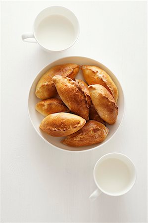 Petits pains fourrés avec du riz et des oeufs avec des tasses de lait (Russie) Photographie de stock - Premium Libres de Droits, Code: 659-06307023