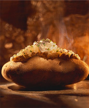 A Steaming Baked Potato with Sour Cream and Chives Stock Photo - Premium Royalty-Free, Code: 659-06307033