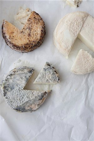 queso de cabra - Three Assorted Goat Cheese Wheels; Each with a Wedge Removed; From Above Foto de stock - Sin royalties Premium, Código: 659-06307137