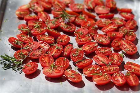 dried tomato - Tomatoes with rosemary on a baking tray to dry Stock Photo - Premium Royalty-Free, Code: 659-06307261