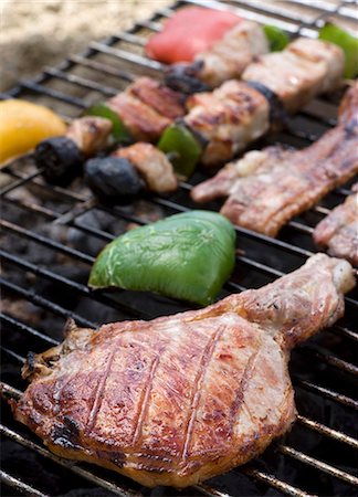 A pork chop, bacon and kebabs on a barbecue Foto de stock - Sin royalties Premium, Código: 659-06307270