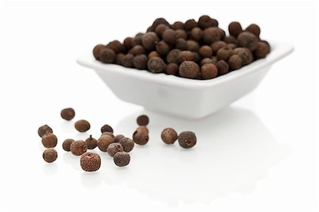 simsearch:659-06307354,k - Allspice berries in a bowl and next to it Foto de stock - Sin royalties Premium, Código: 659-06307405