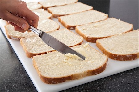 spreading butter on bread - Spreading Butter on Bread in Preparation for an Omelet Casserole Stock Photo - Premium Royalty-Free, Code: 659-06307458