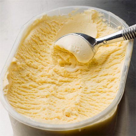 Vanilla ice cream in a plastic container with an ice cream scoop Stock Photo - Premium Royalty-Free, Code: 659-06307481