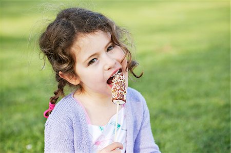 A little girl eating marshmallows Stock Photo - Premium Royalty-Free, Code: 659-06307502