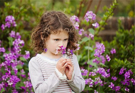 rizado - A little girl smelling flowers in a garden Foto de stock - Sin royalties Premium, Código: 659-06307514