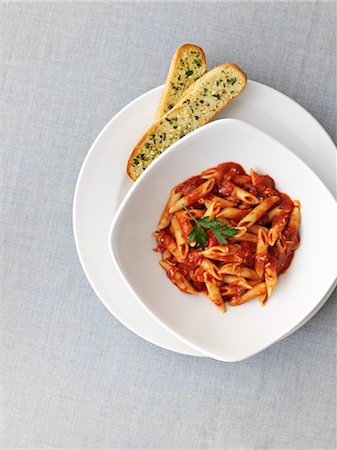 pane all'aglio - Penne with tomato sauce and garlic bread (seen from above) Fotografie stock - Premium Royalty-Free, Codice: 659-06307539