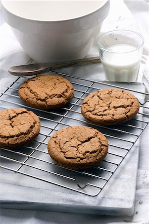 Fresh Homemade Molasses Cookies on a Cooling Rack; Glass of Milk Stock Photo - Premium Royalty-Free, Code: 659-06307604