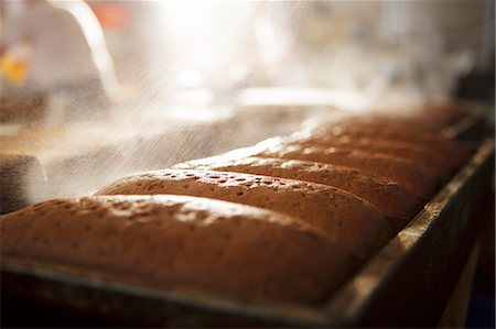 Loaves of bread being sprayed with water Stock Photo - Premium Royalty-Free, Code: 659-06307649