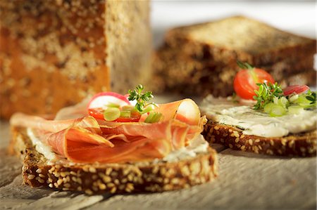 Slices of wholemeal bread topped with ham, herb quark and vegetables Stock Photo - Premium Royalty-Free, Code: 659-06307652