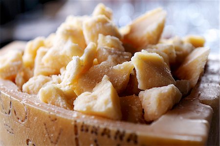 parmigiano-reggiano - Pieces of Parmesan cheese in a hollowed out wedge of Parmesan Foto de stock - Sin royalties Premium, Código: 659-06307842