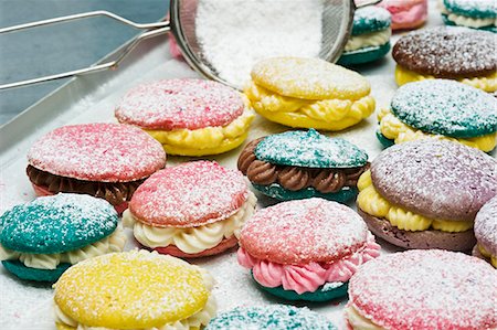 Various macaroons dusted with icing sugar on a baking tray Foto de stock - Sin royalties Premium, Código: 659-06372473