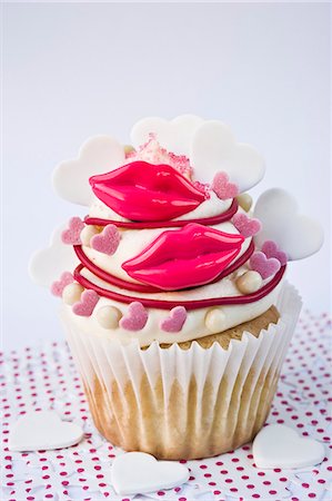 A cupcake decorated with red lips and sugar hearts for Valentine's Day Foto de stock - Sin royalties Premium, Código: 659-06372492