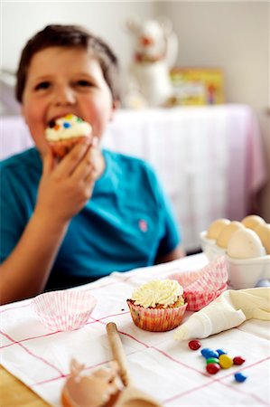 Young boy eating a cupcake Stock Photo - Premium Royalty-Free, Code: 659-06372521