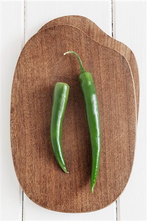 Two green chilli peppers on a chopping board Stock Photo - Premium Royalty-Free, Code: 659-06372596