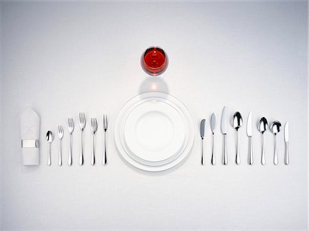 Plates, cutlery, a napkin and a glass of red wine Stock Photo - Premium Royalty-Free, Code: 659-06372656