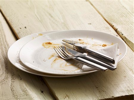 food on wooden table - A dirty plate with cutlery and a paper napkin Stock Photo - Premium Royalty-Free, Code: 659-06372721